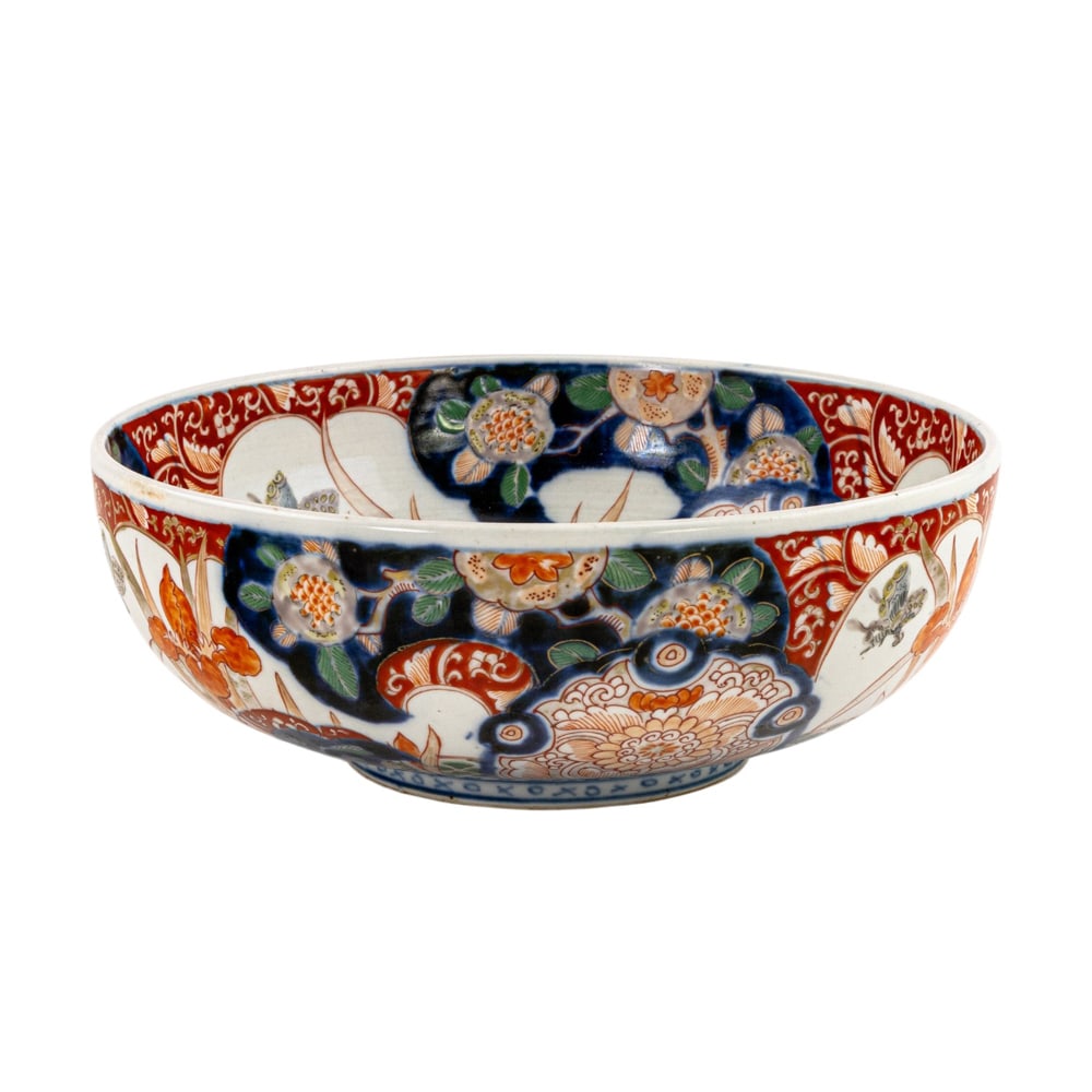 A large Japanese Imari bowl: A large Japanese Imari bowl. Depicting butterfly, iris, and stylized floral motif, with underglaze blue and overglaze multi-color enamel decoration, 9.75" across.