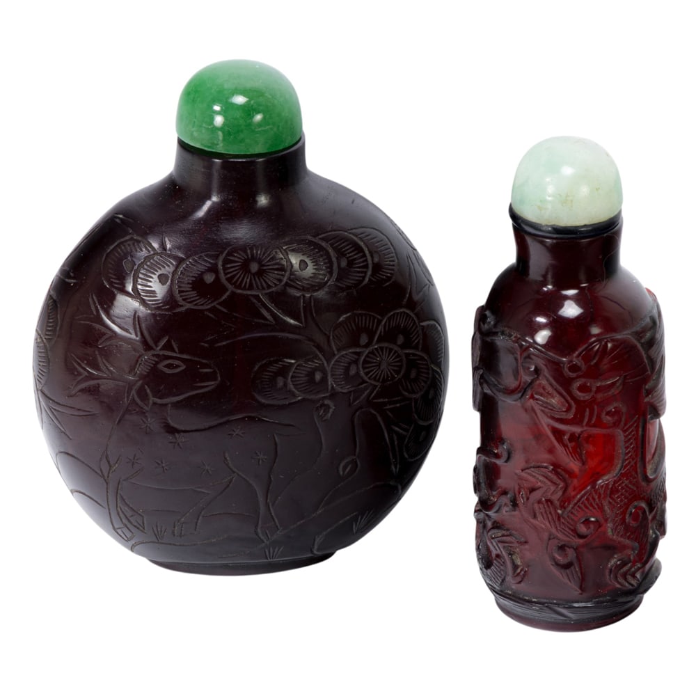(lot of 2) Chinese ruby red Peking glass carved snuff bottles: (lot of 2) Chinese ruby red Peking glass carved snuff bottles. Comprising one carving with deer and lingzhi motif, and one carving with dragon motif, Republic period, from 3.625" to 3.75" tall.