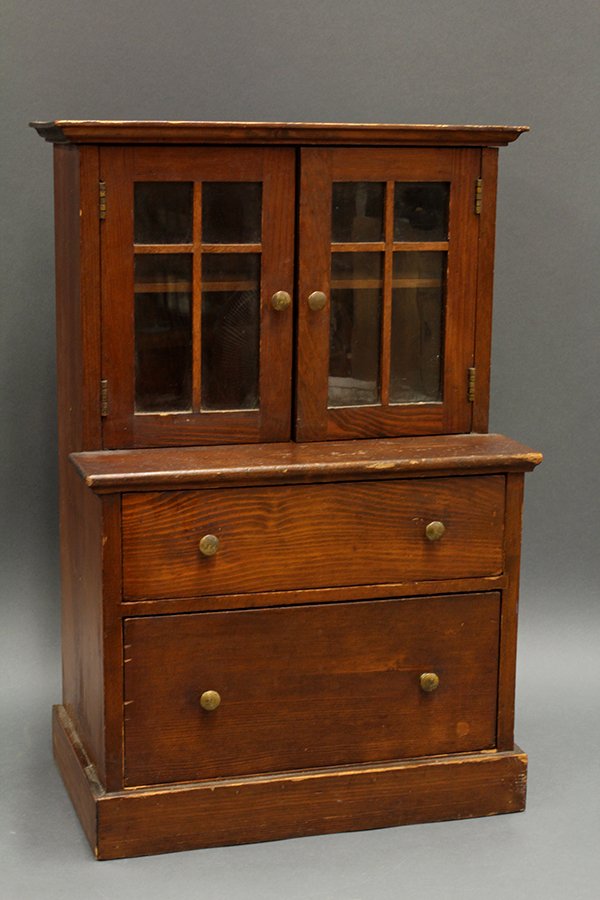 Miniature step-back cupboard: Miniature step-back cupboard,.having a molded cornice surmounting two doors with brass knobs above a two drawer case, the whole rising on a molded base, 26"h x 17"w x 9.5"d.
