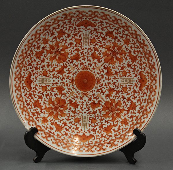 Chinese Orange Enameled Charger: Chinese enameled porcelain charger, decorated with stylized lotus blossoms alternating with bats and shou emblems on a scroll ground bound within a ruyi band (rim chip), 13.25"w