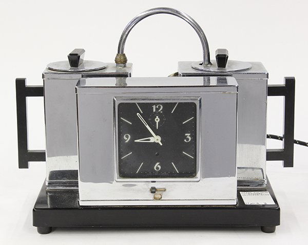 Mid century chrome mantle clock: English, Art Deco chrome mantle clock, the chrome case with two tea pots having a conforming surface and rising on an ebonized base 8.5"h x 12"w x 6"d