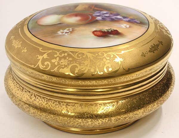 Limoges round covered box: Limoges round covered box having a central transfer decorated reserve depicting a still life of fruit on a gilt ground, 7.5"w