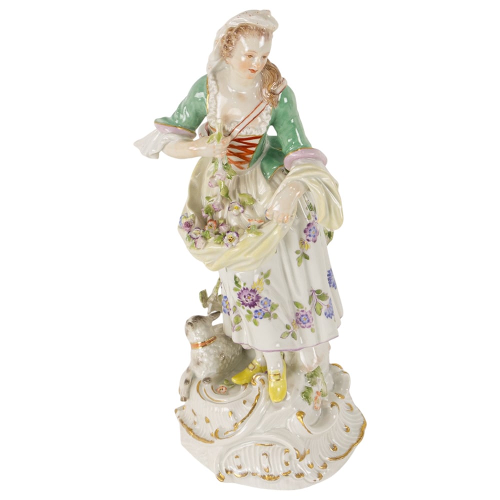 A Meissen porcelain figure of a female gardener: A Meissen porcelain figure of a female gardener, underglaze blue crossed swords with double cancellation, the woman holding flowers in her skirt and a lamb at her feet, 10.5"h x 4"dia