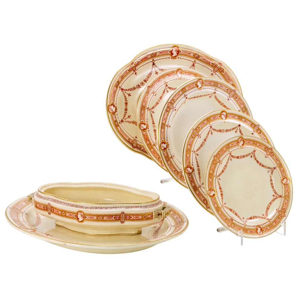 A Wedgwood Queensware partial dinner service decorated in the Greek Revival style: A Wedgwood Queensware partial dinner service decorated in the Greek Revival style, decorated in iron red and gilt with cameos and floral swags, impressed 'WEDGWOOD' and various date codes, comprising