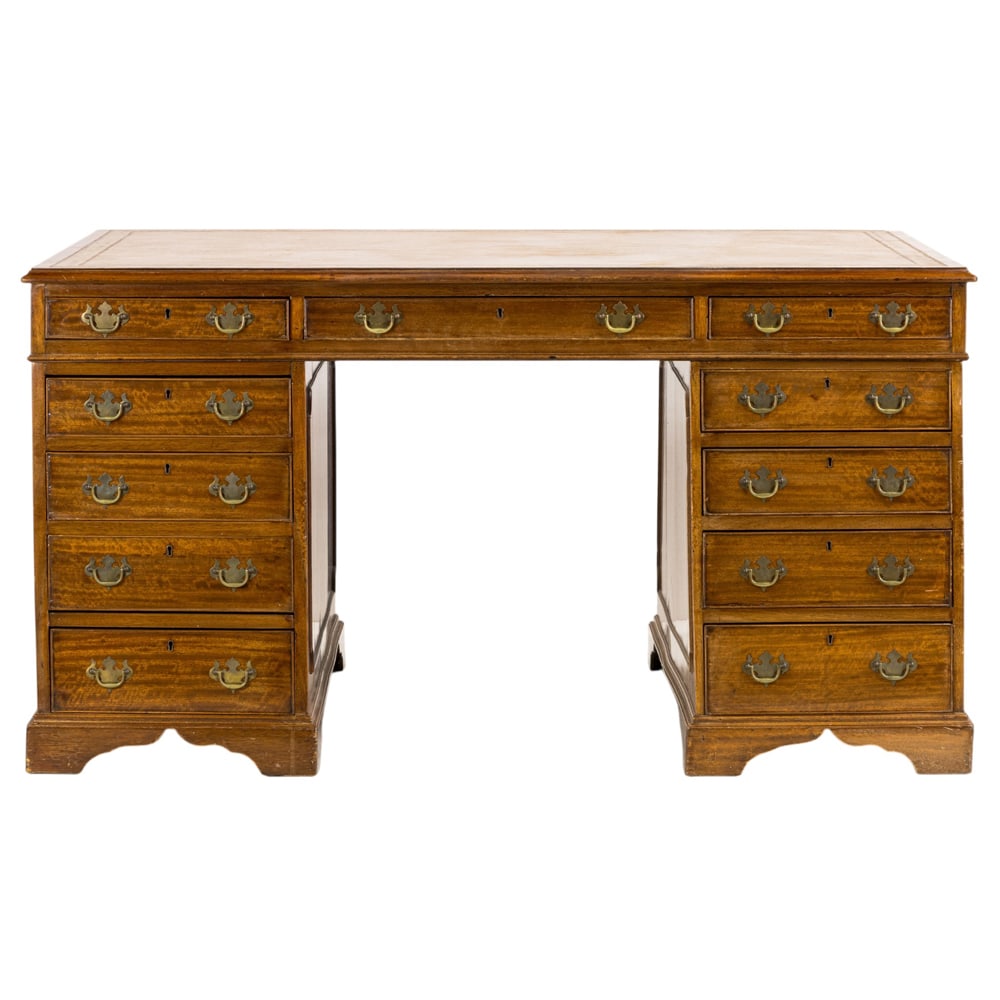 A George III mahogany partners desk: A George III mahogany partners desk, the large form with two banks of drawers, each having quilted mahogany fronts, and rising on bracket feet, 33"h x 59.5"w x 47"d