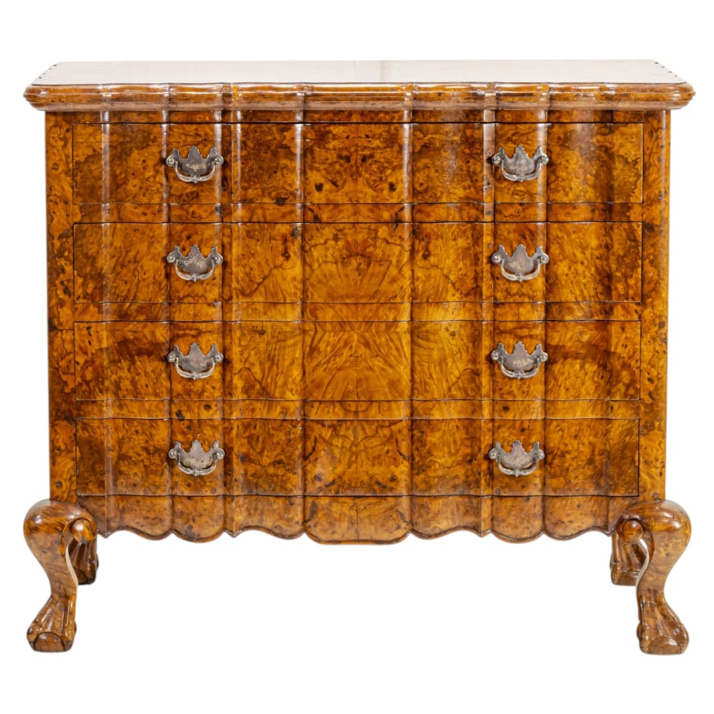 A Baroque style chest of drawers: A Baroque style chest of drawers, the highly figured burl veneer case with four drawers each with oak secondary woods, conforming scallop apron, and rising on robust claw and ball feet, 36"h x 41"w x