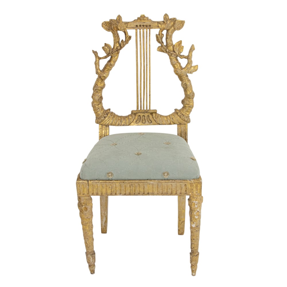 An Italian giltwood carved salon chair 18th century: An Italian giltwood carved salon chair 18th century, the branch form lyre back with leaf and vine sprays with cut velvet and silk drop in seat, Provenance: acquired from Guido del Borgo Antichita,