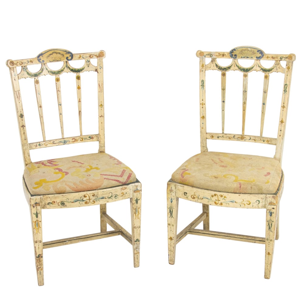 A pair of English polychrome side chairs first 19th century: A pair of English polychrome side chairs first 19th century, the back with horizontal slats above the garland decorated reserve, later drop in needlepoint seat, and rising on square tapered legs,