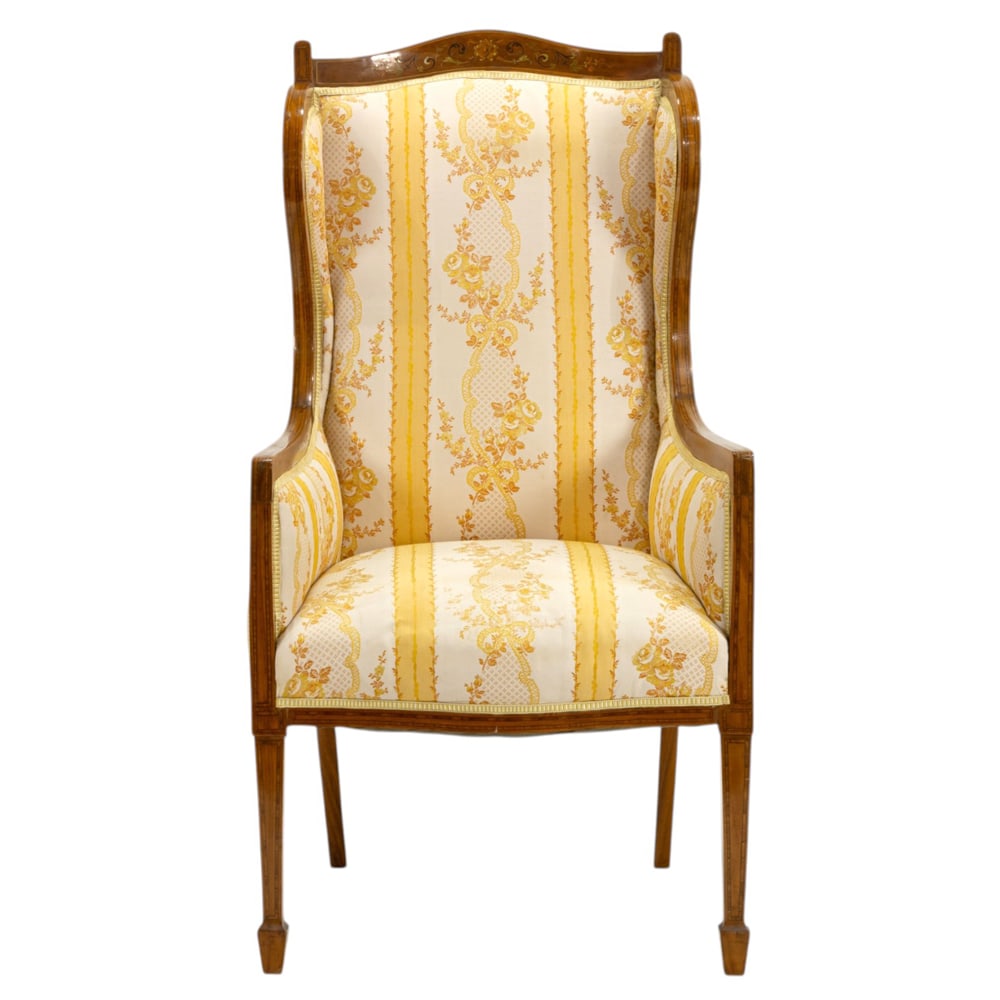 An Edwardian inlaid inlaid wing chair: An Edwardian inlaid inlaid wing chair, the high back with yellow and white striped damask upholstery, and rising on square, tapered legs, 46"h x 24"w x 27"d (overall) ; 20"h x 20.5"d (seat). Property