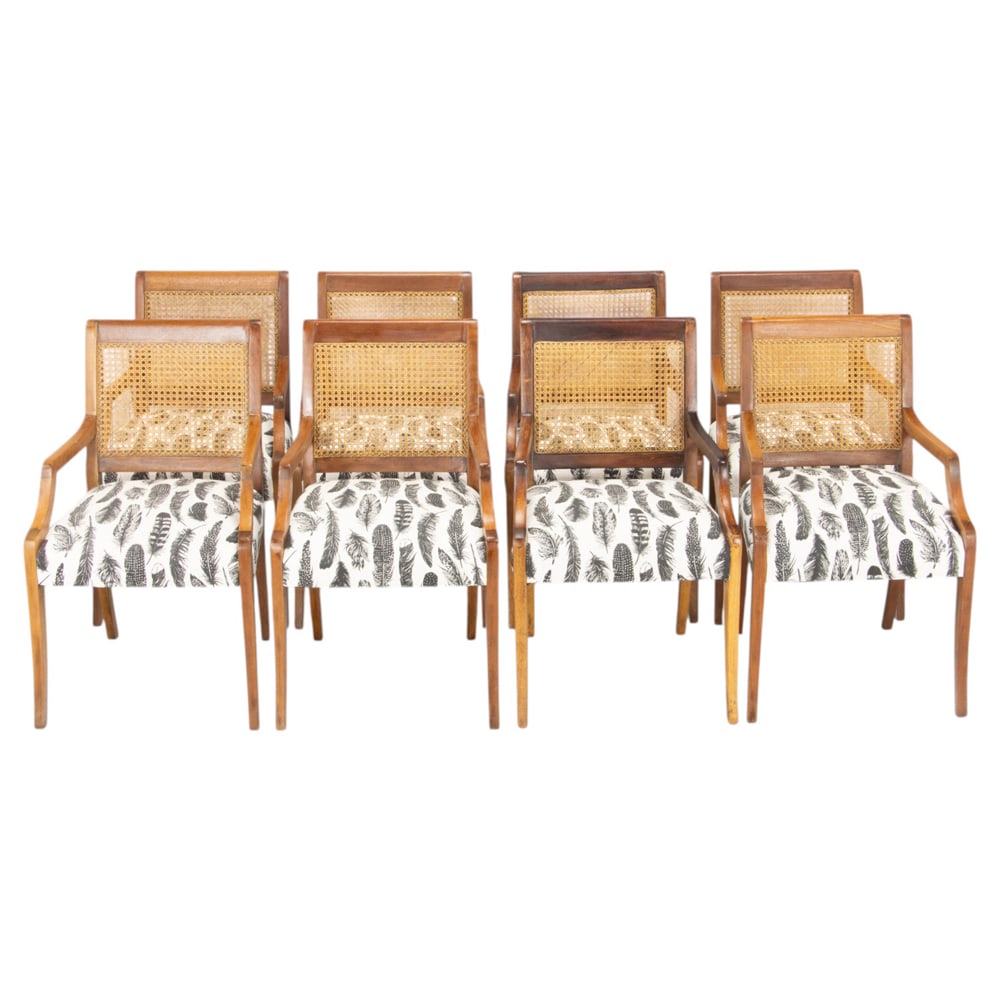 A set of eight cane back armchairs: A set of eight cane back armchairs, each with sloping returns continuing to the feather print decorated upholstered seats , 34"h x 21"w x 22.5"d (overall); 20.5"h x 19.5"d (seat)