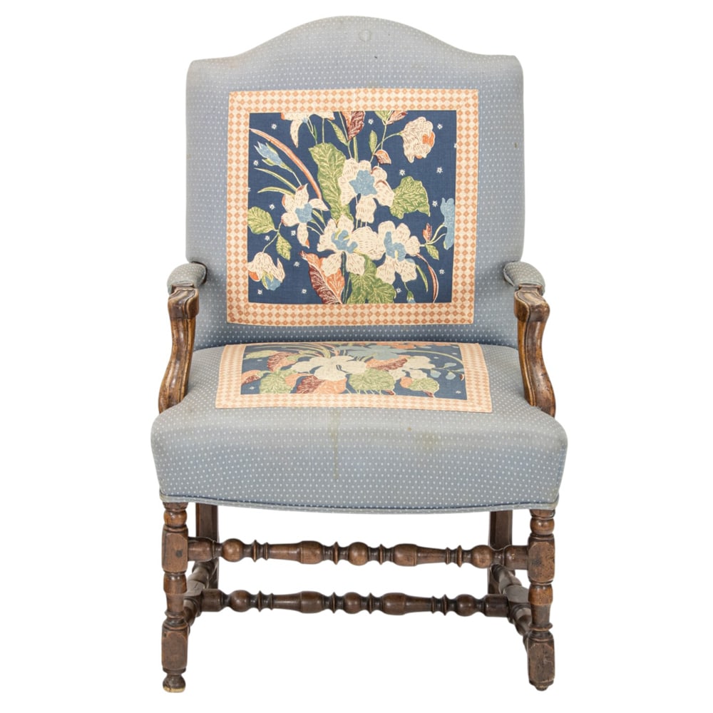 A French armchair in the Provincial taste circa 1850: A French armchair in the Provincial taste circa 1850, the camel back with outswept arms, and rising on a block and turned base, 43.5"h x 25.5"w x 28"d (overall); 21"h x 19"d (seat)