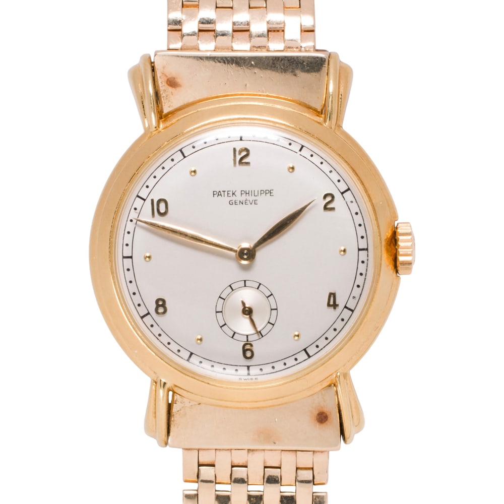 A 1950s Patek Philippe 18k yellow gold wristwatch: A 1950s Patek Philippe 18k yellow gold wristwatch a silvered dial with applied dot and Arabic numerals, subsidiary seconds dial, manual wind movement #953518, 18 jewel, adjusted to five positions, wit