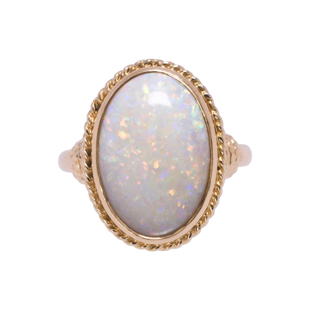 An opal and 14k gold ring: An opal and 14k gold ring Centering an oval-shaped opal cabochon measuring 17.39 x 12.12 mm; size 8 1/4; 5.50 grams