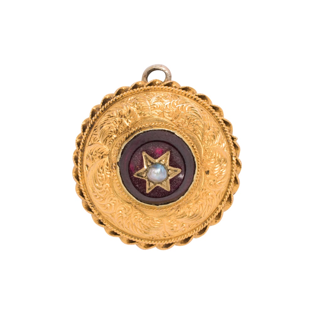 An antique 14k hair locket pendant: An antique 14k hair locket pendant originally a brooch, with half pearl and pink glass center; diameter: 7/8 in; 3.77 grams