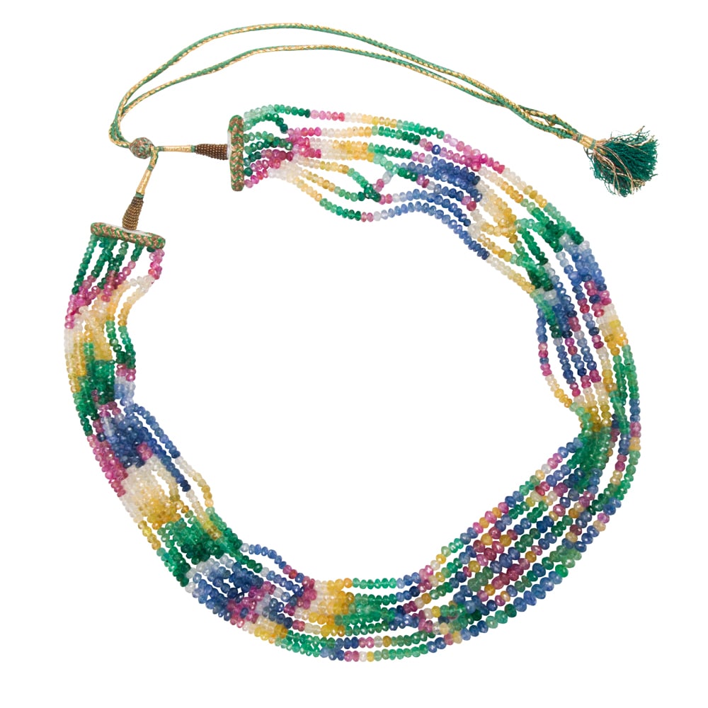 A gemstone and silk beaded necklace: A gemstone and silk beaded necklace Of South Asian design, featuring seven strands of button-shaped, faceted sapphire and emerald beads on woven silk tassels; length: 40 in (adjustable); 156.20 grams