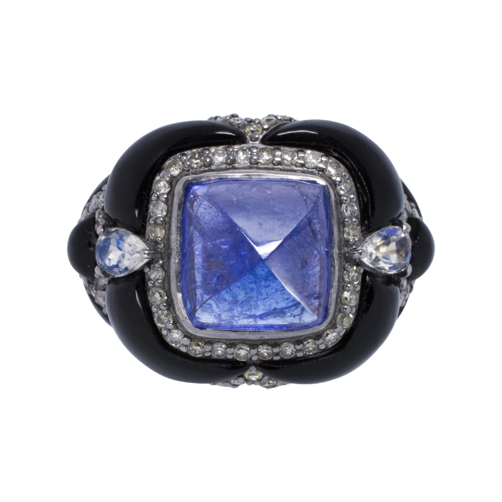 A tanzanite, onyx, moonstone, diamond, silver, and 14k gold ring: A tanzanite, onyx, moonstone, diamond, silver, and 14k gold ring Centering a sugarloaf tanzanite cabochon weighing 5.40 carats, accented by onyx lobes, round-cut diamonds, and pear-cut moonstones,