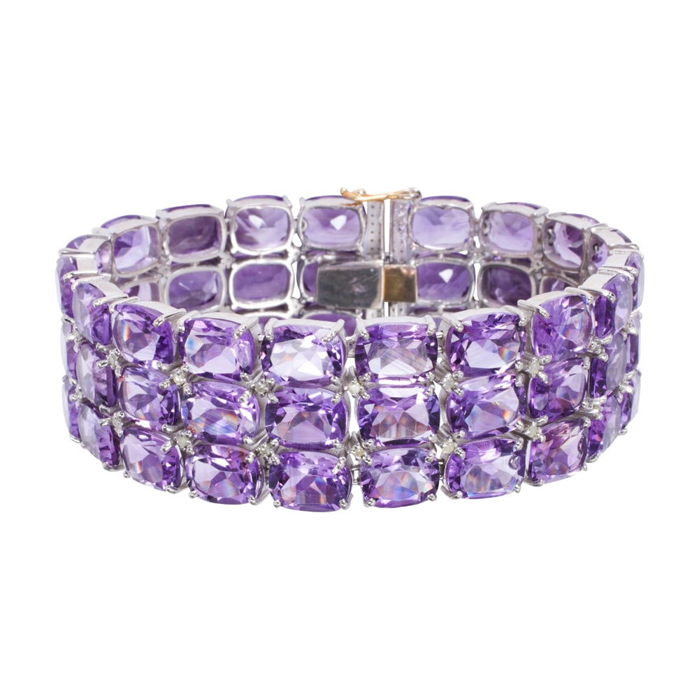 An amethyst, diamond, silver, and 14k gold bracelet: An amethyst, diamond, silver, and 14k gold bracelet The silver bracelet set with numerous oval-cut amethysts weighing a total of 105.40 carats, accented by round-cut diamonds, with 14k gold clasp