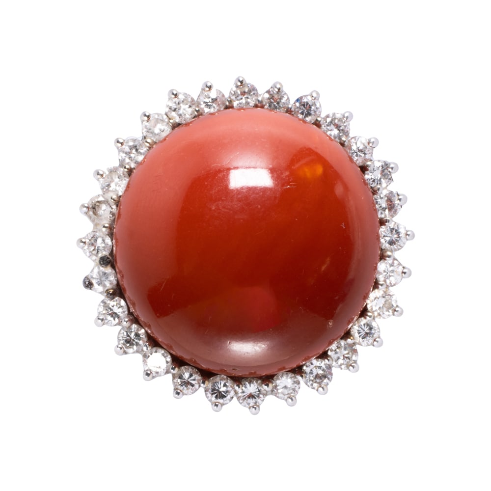 A coral, diamond, and 14k white gold ring: A coral, diamond, and 14k white gold ring Centering a round-shaped coral cabochon measuring 21.58 mm across, with round brilliant-cut diamond surround; estimated total diamond weight: 2.20 carats;