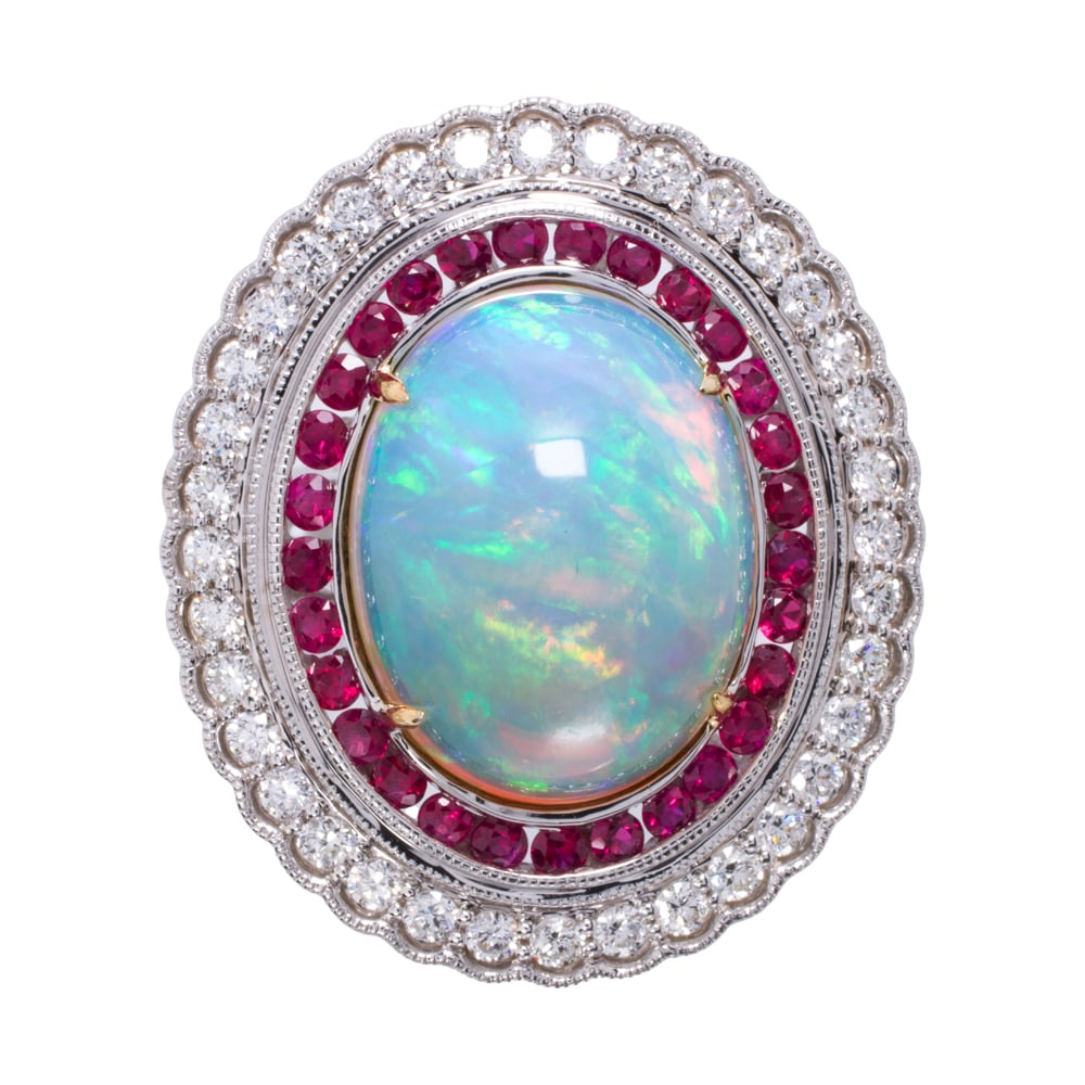 An opal, ruby, diamond, and 14k white gold ring: An opal, ruby, diamond, and 14k white gold ring Set with an oval-shaped opal cabochon measuring 16.66 x 12.80 mm, framed by one round-cut ruby halo and one round brilliant-cut diamond halo, with