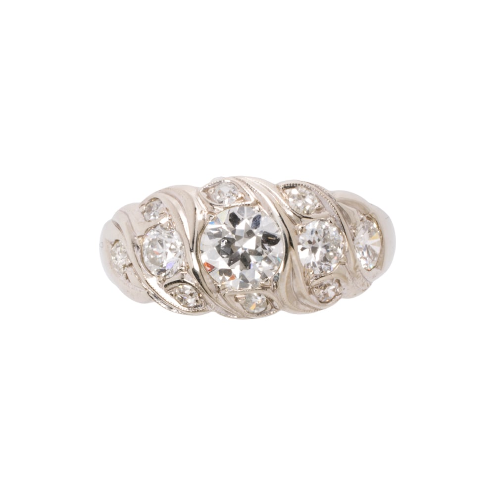 A diamond and 14k white gold ring: A diamond and 14k white gold ring Of repeating wave design, centering a round brilliant-cut diamond weighing 0.60 carat, accented by 10 round brilliant-cut diamonds weighing 0.66 carat total; size 7