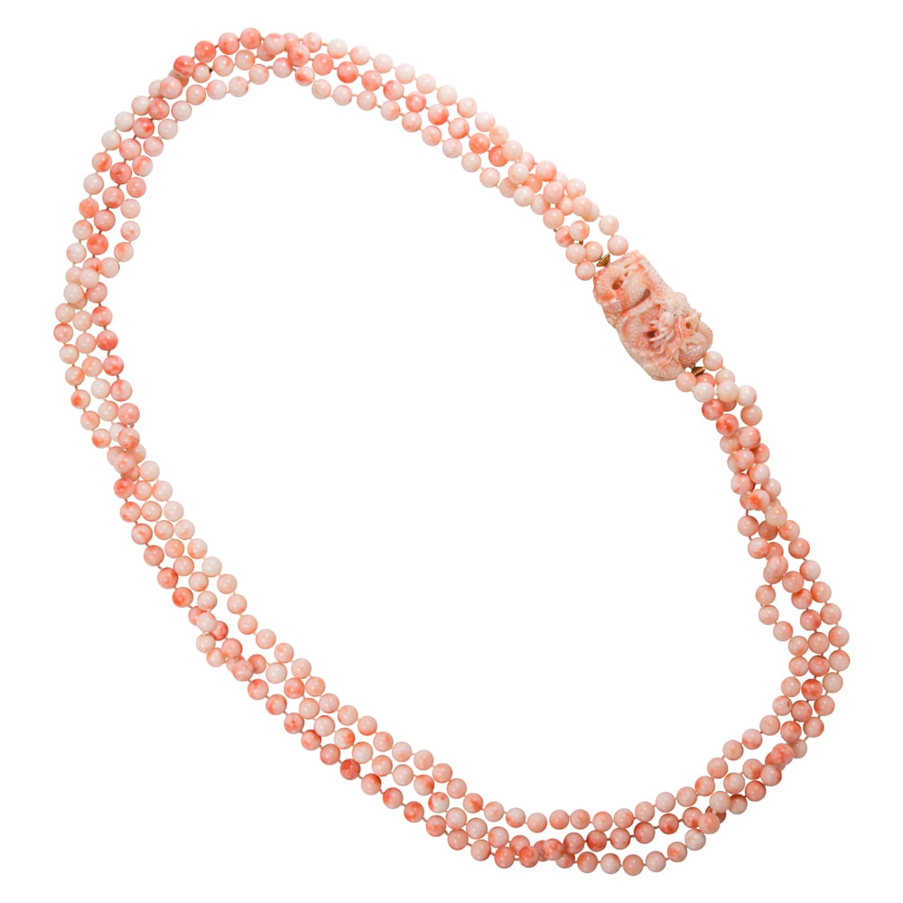A coral beaded necklace: A coral beaded necklace Designed as three strands of round-shaped coral beads measuring 8.30 mm, joined by an intricately carved dragon measuring 2 x 1 1/8 in; length: 38 in; 229.00 grams