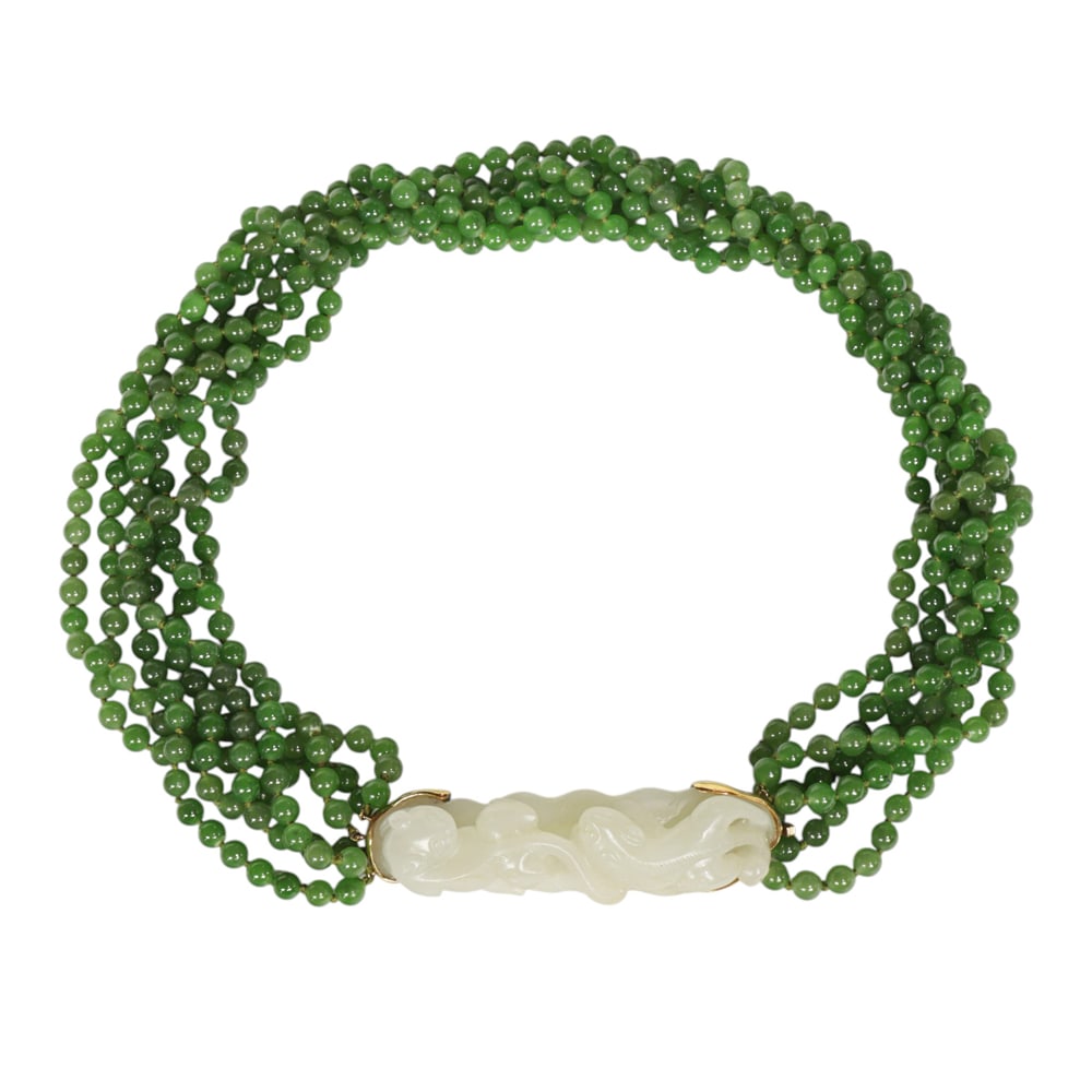 A Chinese white jade and spinach jade pendant necklace: A Chinese white jade and spinach jade pendant necklace. Comprising of polished spinach jade beads, suspending a carved white jade pendant depicting two mythical beasts, 3.25" width of the pendant, 19"