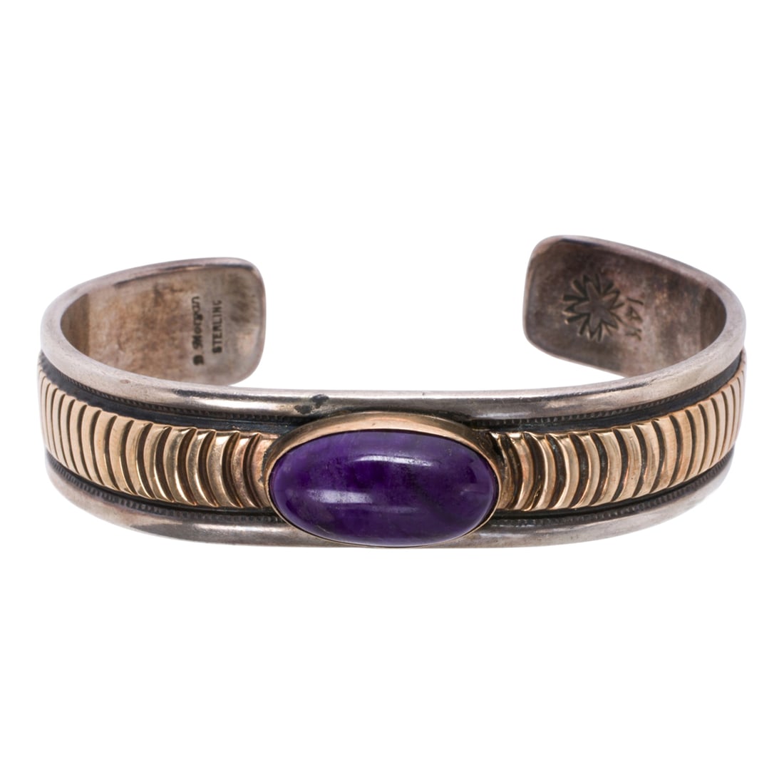 A Morgan hardstone, silver, and 14k gold cuff bracelet: A Morgan hardstone, silver, and 14k gold cuff bracelet Centering an oval-shaped purple hardstone, with geometric 14k gold accents; length: 5 1/4 in; 42.45 grams