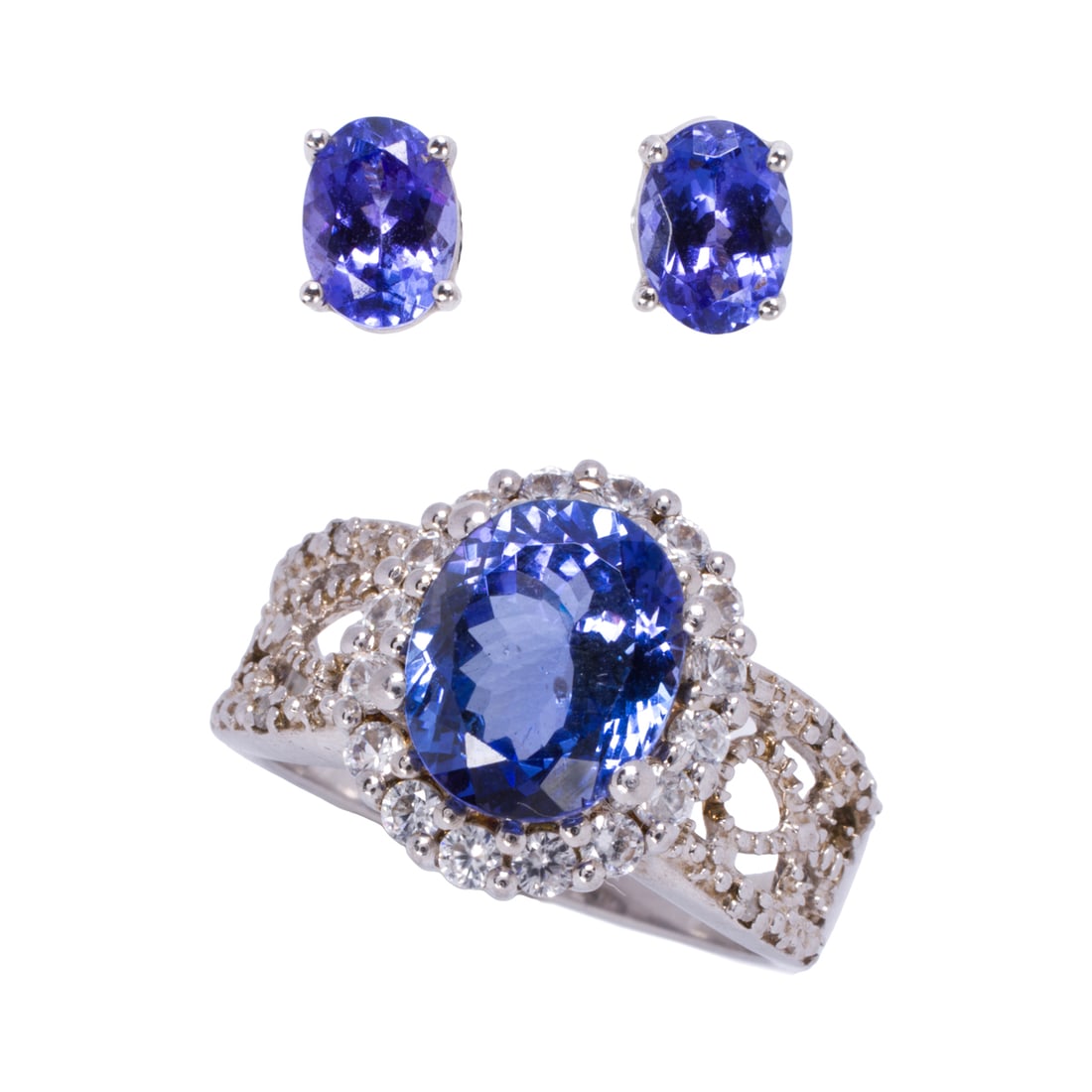 A tanzanite, 14k white gold, and silver ring and earrings: A tanzanite, 14k white gold, and silver ring and earrings Comprising one silver ring set with an oval-cut tanzanite measuring 9.88 x 8.16 mm, framed by round-cut cubic zirconia, together with a pair o