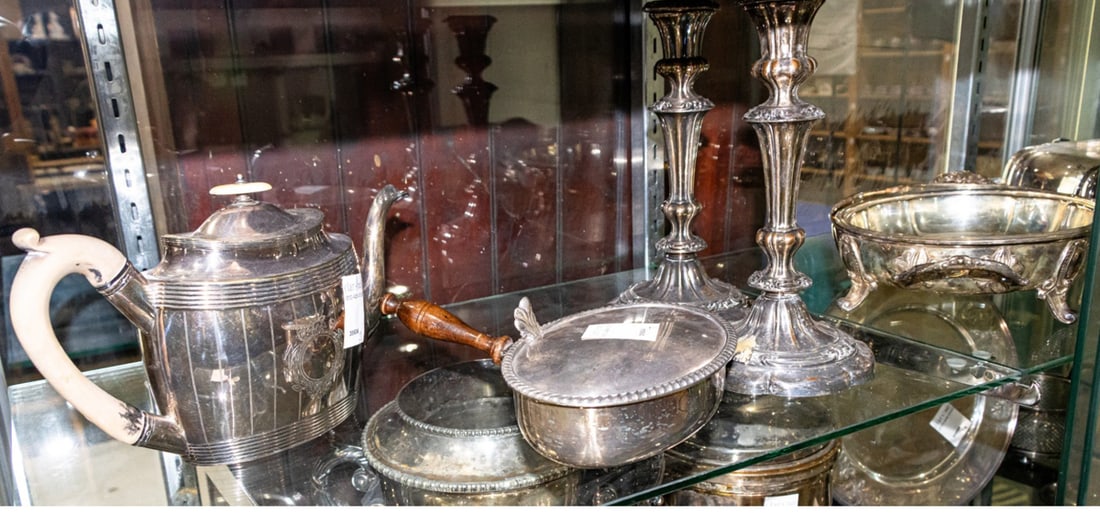 An assembled group of silver plate: An assembled group of silver plate, mostly serving ware, consisting of (1) teapot; (1) silent butler; (2) serving dishes one with lid, together with (2) candle sticks [7 total]