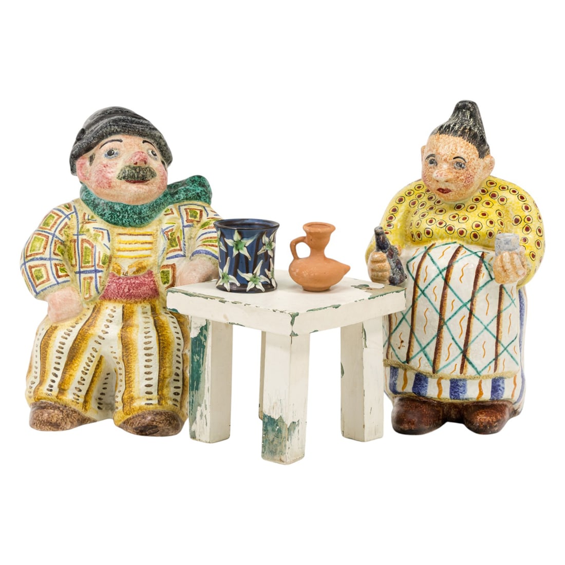 A whimsical Italian pottery group: A whimsical Italian pottery group, composed of figures of a man and woman seated at a wood table, label marked 'PERUGIA', greatest 10.5"h