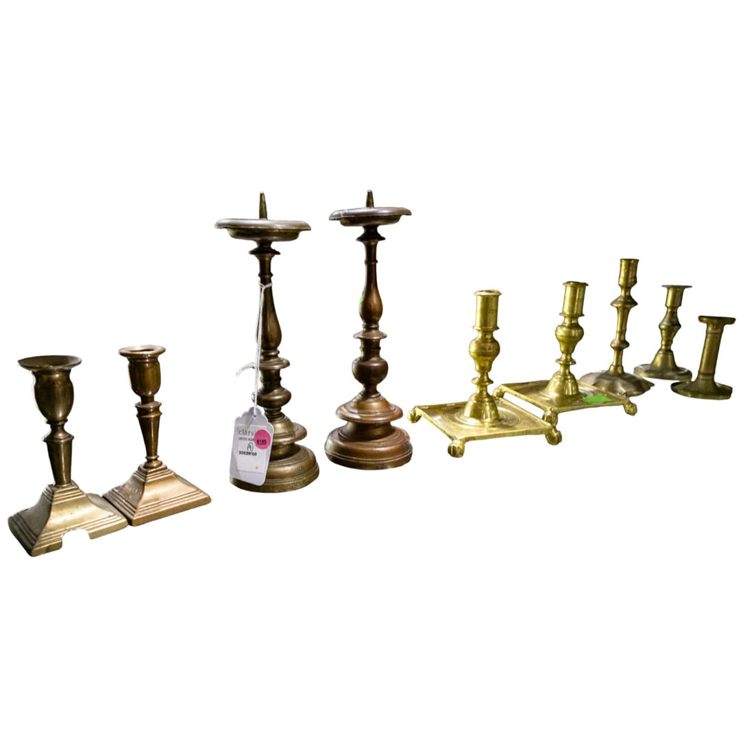A group of nine brass and bronze candlesticks: A group of nine brass and bronze candlesticks, 18th/19th/20th century, comprising a pair of Baroque candleprickets; pair of Colonial Williamsburg for Virginia Metalcrafters candlesticks with square