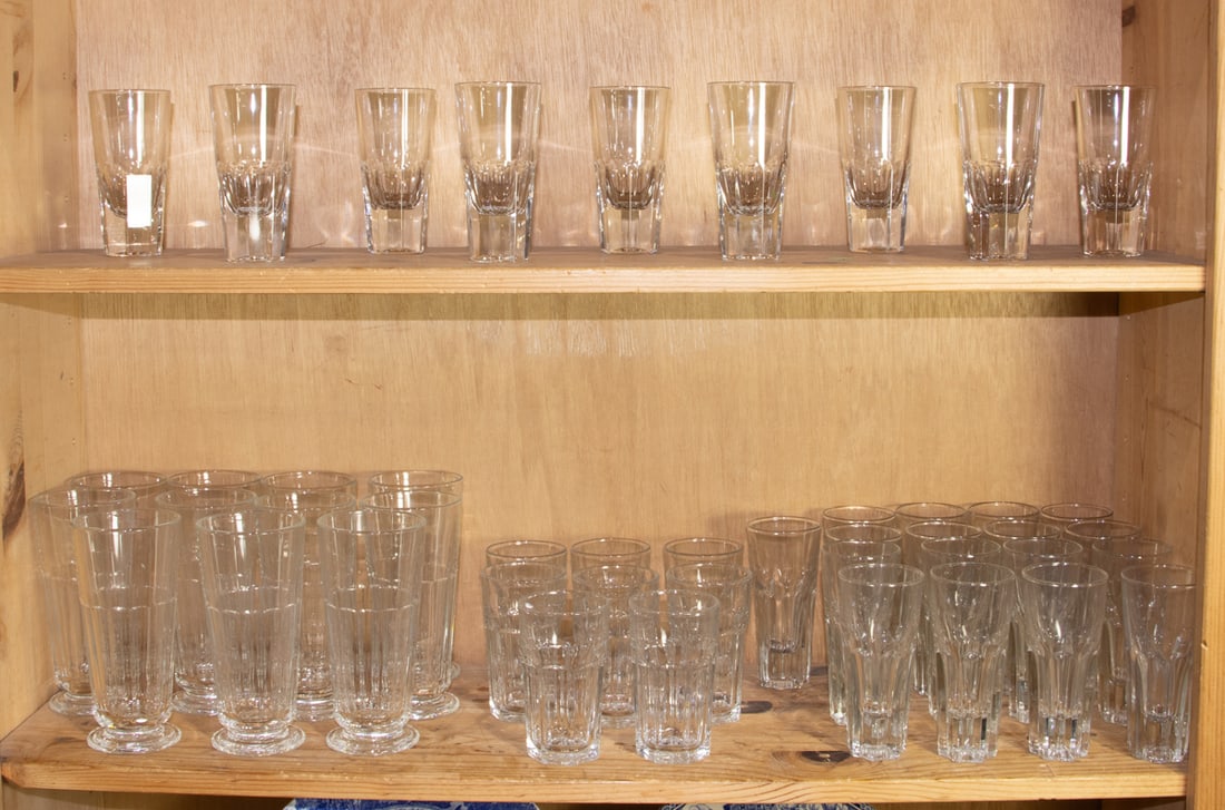 An assembled group of glass drinkware: An assembled group of glass drinkware, comprising (11) La Rochere long drink glasses; (9) cordials; (8) Libbey tumblers and (17) fluted tumblers [45 total]