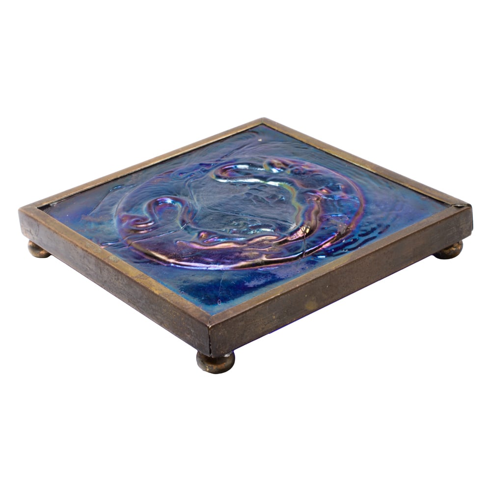 A Tiffany Furnaces bronze mounted Favrile iridescent glass Dragon tile trivet (1 of 3)