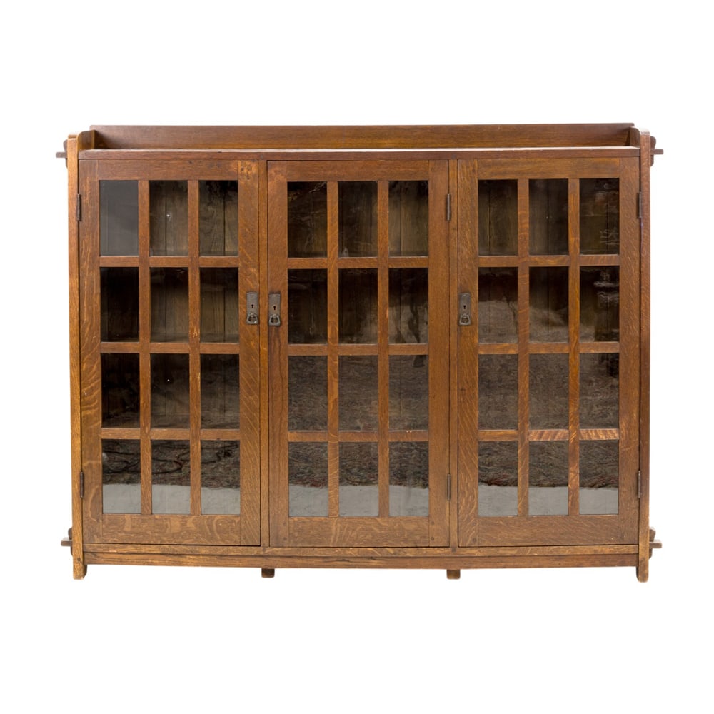 An early L & J.G Stickley bookcase: An early L & J.G Stickley bookcase, #331 1/2, from the Onondaga Shops, three door form with original copper hardware and twelve panes per door, key and tenon construction, 55"h x 69.5"w x 12"d