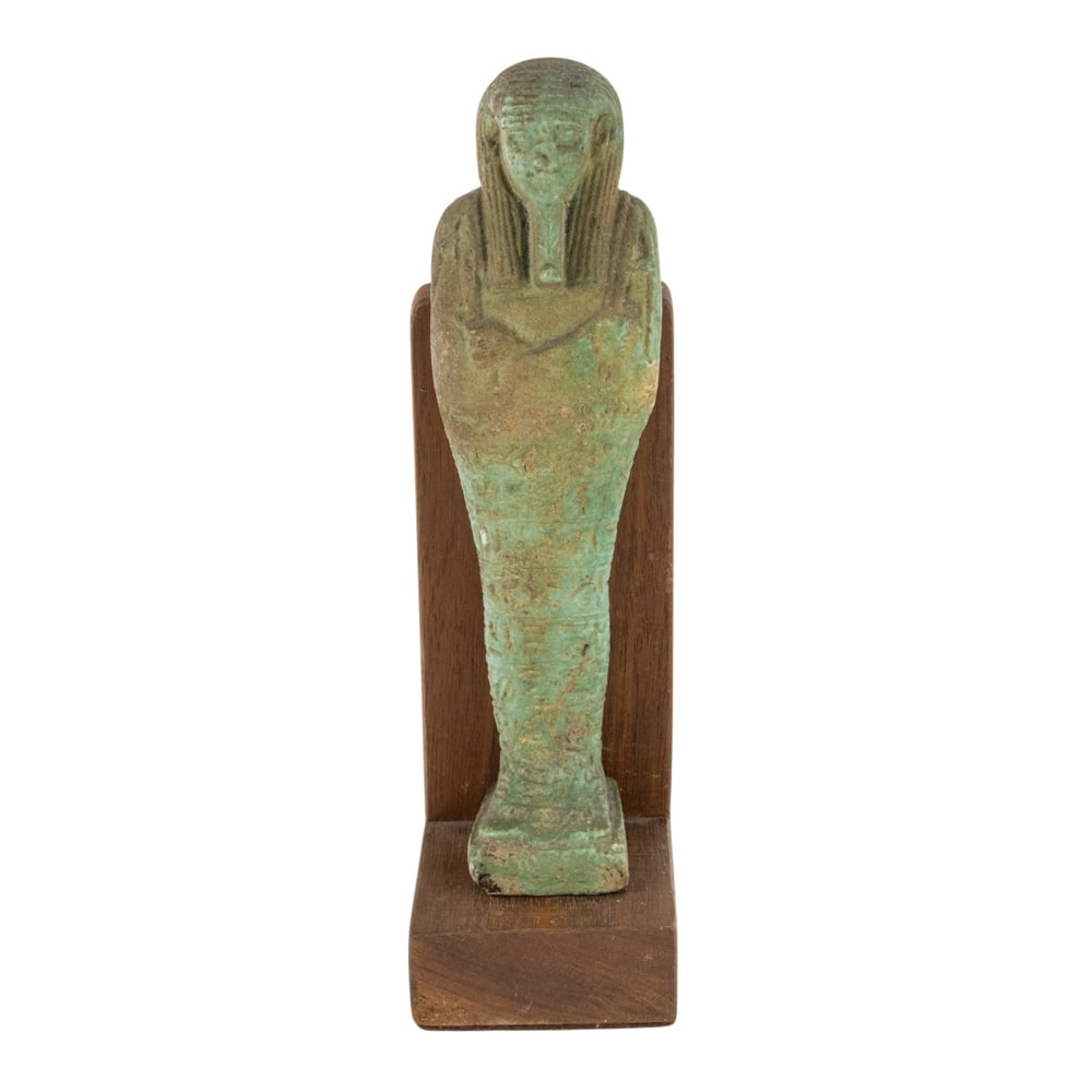 An Egyptian turquoise glazed ushabti: An Egyptian turquoise glazed ushabti, the body inscribed with horizontal hieroglyphs, with rear pillar continuing to the shoulders, with later stand, 6.5"l