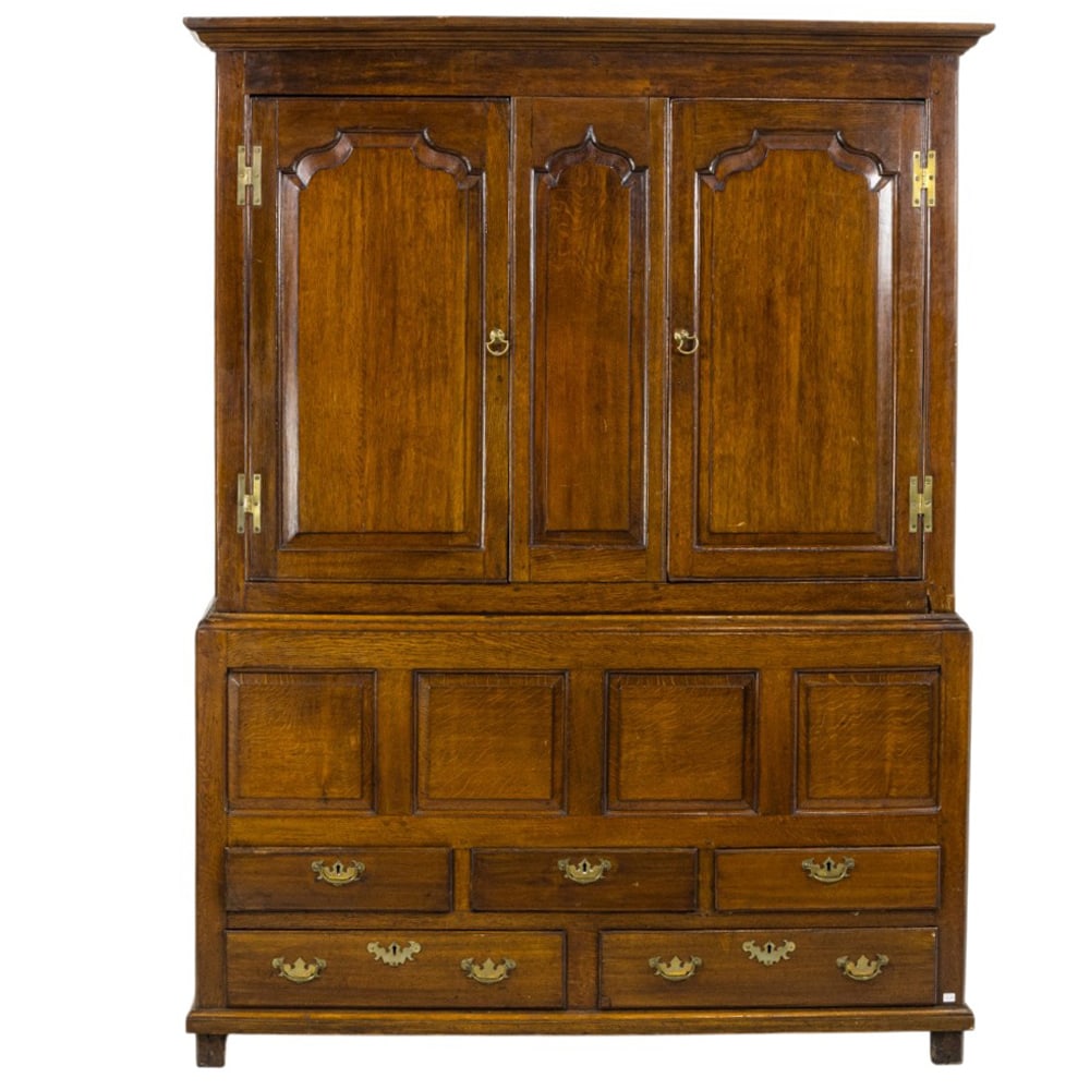 A George II oak livery cabinet, 18th century: A George II oak livery cabinet 18th century, the paneled case in two parts, and rising on a molded base, 81.5"h x 61.5"w x 22.5"d
