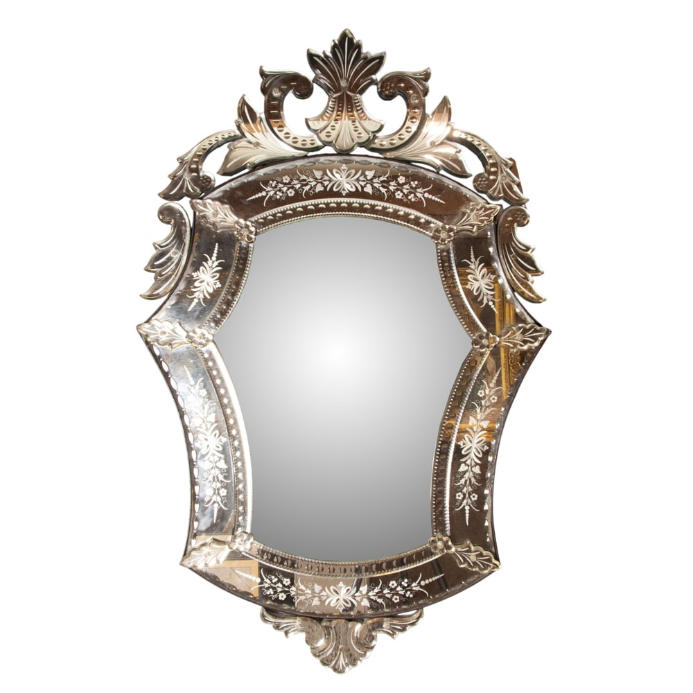 A Venetian reverse engraved glass mirror: A Venetian reverse engraved glass mirror, of shield form with scrolled crest, 46"h x 29"w x 1.5"d