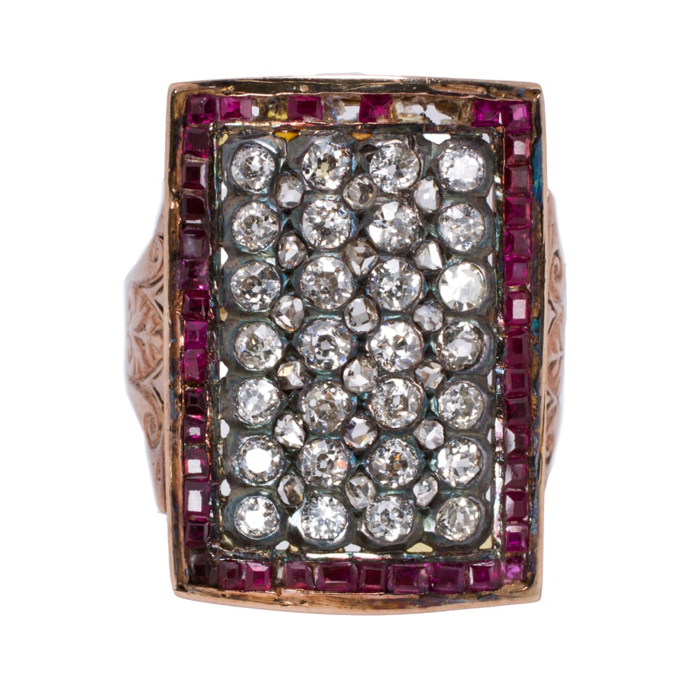 An antique diamond, ruby, and 14k gold men's ring: An antique diamond, ruby, and 14k gold men's ring Designed as a rectangular arrangement of 30 old mine-cut diamonds, interspersed by 18 rose-cut diamonds, within square-cut ruby frame with scrolled sh