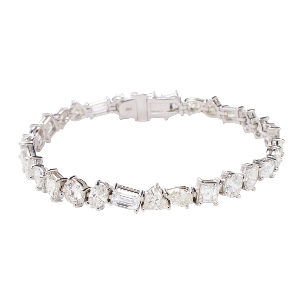 A diamond and 14k gold tennis bracelet: A diamond and 14k gold tennis bracelet designed as a line of various cut diamonds; estimated total diamond weight: 12.85 carats; length: 7 in; 15.10 grams