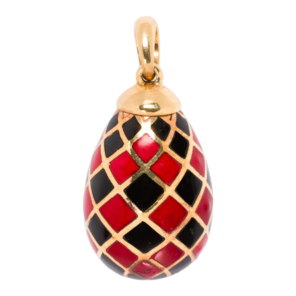 An enamel and 18k gold pendant: An enamel and 18k gold pendant Designed as an egg with a checkerboard of red and black enamel; length: 1 1/4 in; 11.60 grams