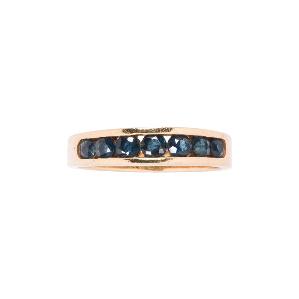 A sapphire and 14k gold band: A sapphire and 14k gold band Set with seven round-cut sapphires weighing approximately 0.90 carat; size 7; 2.95 grams
