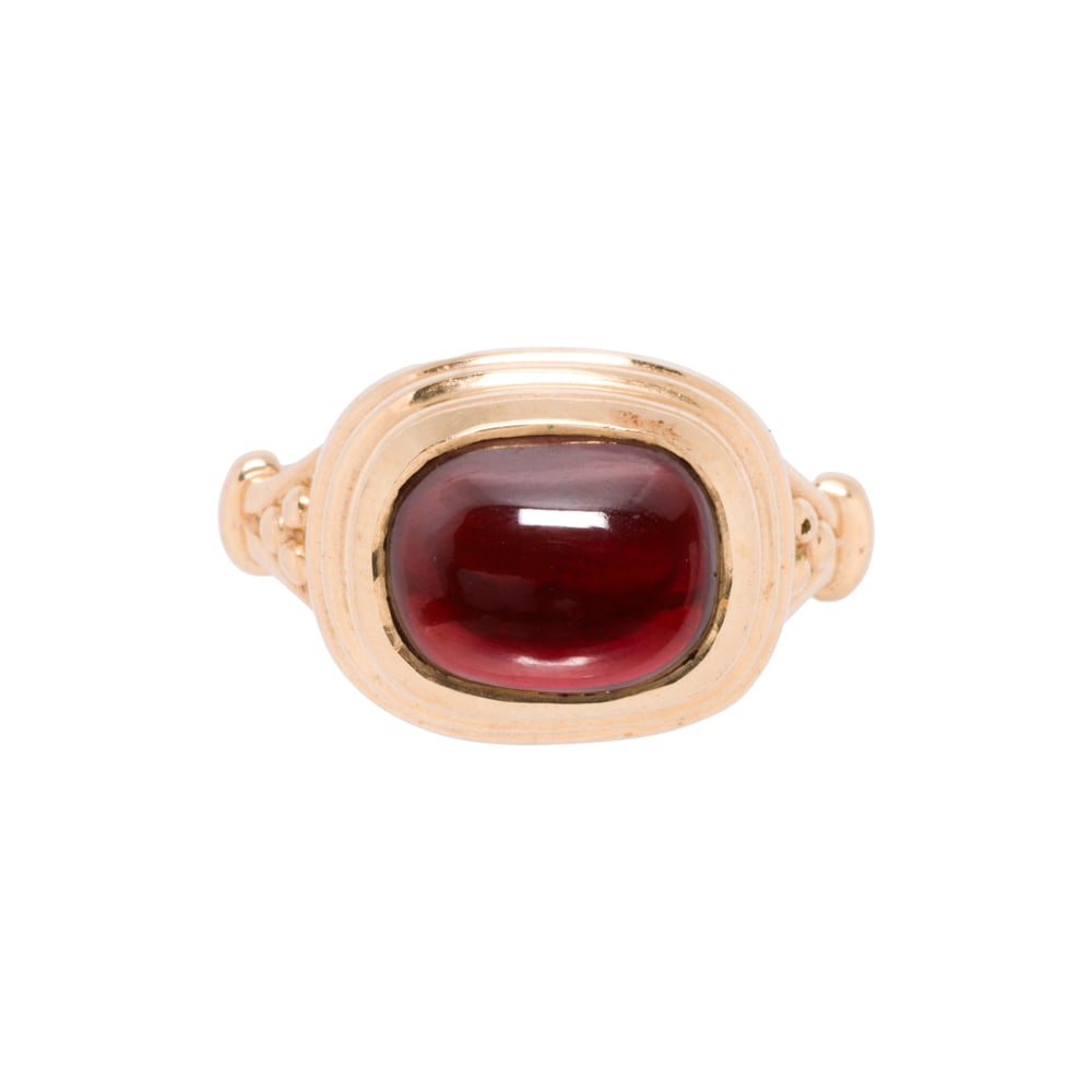 A garnet and 14k gold ring: A garnet and 14k gold ring Of Byzantine design, centering an oval-shaped garnet cabochon measuring 9.94 x 7.75 mm; size 7 1/4; 5.20 grams
