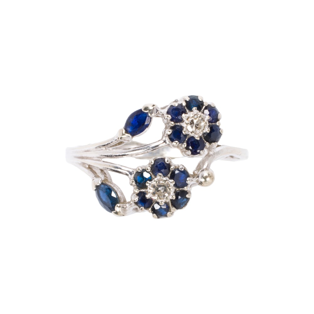 A diamond, sapphire, and 14k white gold ring: A diamond, sapphire, and 14k white gold ring Of floral design, set with 14 marquise and round-cut sapphires and two round brilliant-cut diamonds; size 7 1/4; 3.35 grams