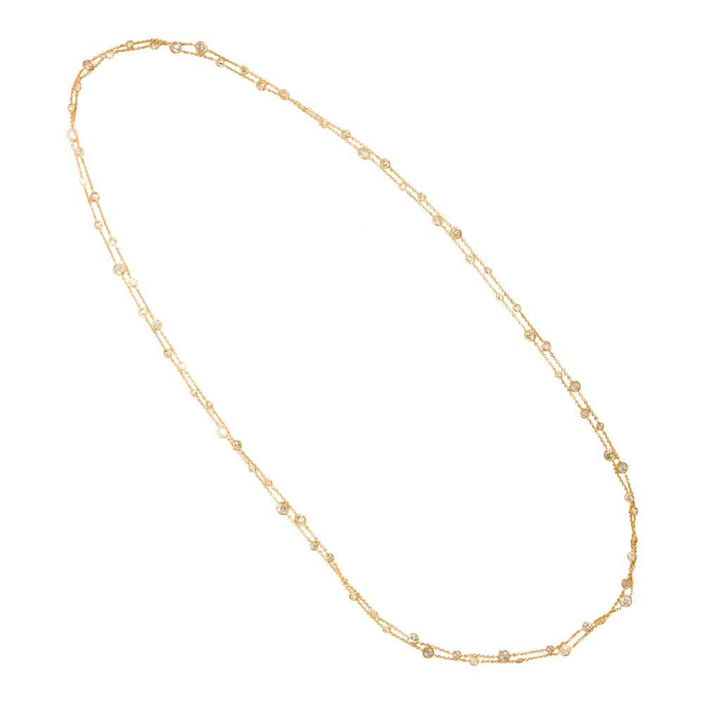 A diamond and 14k gold necklace: A diamond and 14k gold necklace featuring numerous bezel-set round brilliant-cut diamonds; estimated total diamond weight: 14.60 carats; length: 60 in; 15.70 grams