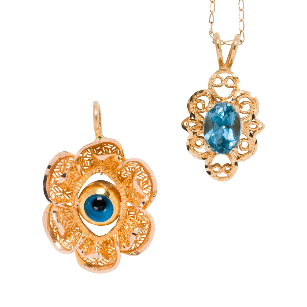 A pair of topaz and 14k gold pendant necklaces: A pair of topaz and 14k gold pendant necklaces each of similar design featuring a round cabochon and a oval-cut topaz; pendant lengths: 1/2 and 1 in; 3.20 gross grams