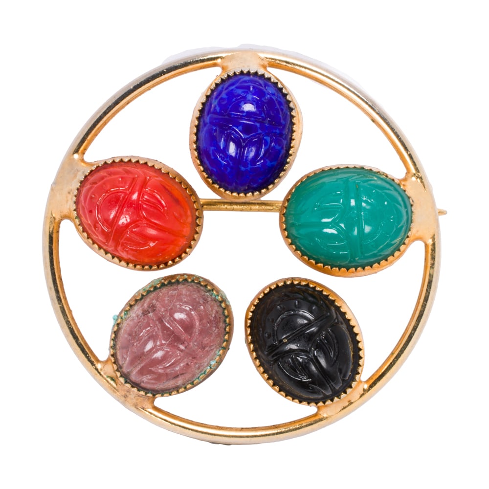 A gemstone and 10k gold brooch: A gemstone and 10k gold brooch featuring 5 scarab carved gemstones; length: 1 1/4 in; 6.00 grams