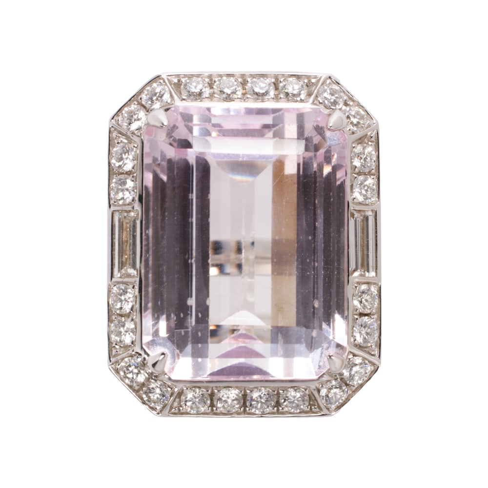 A kunzite, diamond, and 18k white gold ring: A kunzite, diamond, and 18k white gold ring Centering an emerald-cut kunzite weighing 40.09 carats, framed within round brilliant and baguette-cut diamonds weighing a total of 2.00 carats; size 7; 22.