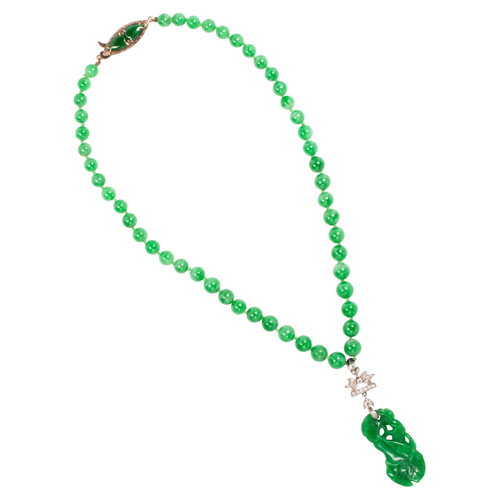 A jade, diamond, platinum and 14k gold pendant necklace: A jade, diamond, platinum and 14k gold pendant necklace composed of 50 round jade beads measuring from 5.60 to 7.10 mm, suspending an art deco pendant featuring a carved jade of gourd, foliate and