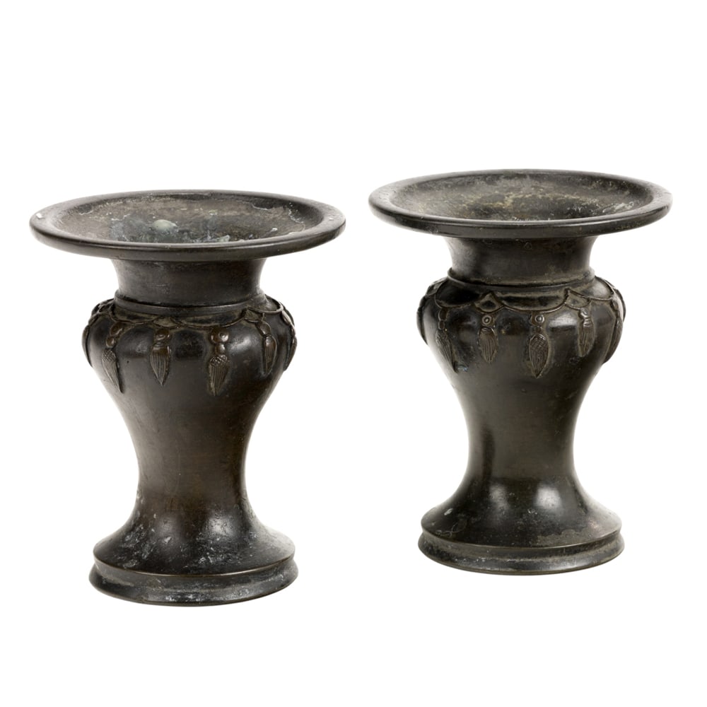 A pair of Chinese cast bronze candle holders: A pair of Chinese cast bronze candle holders. Of meiping form with a wide trumpet mouth and spreading foot, 17th/18th century, 4.625" high.