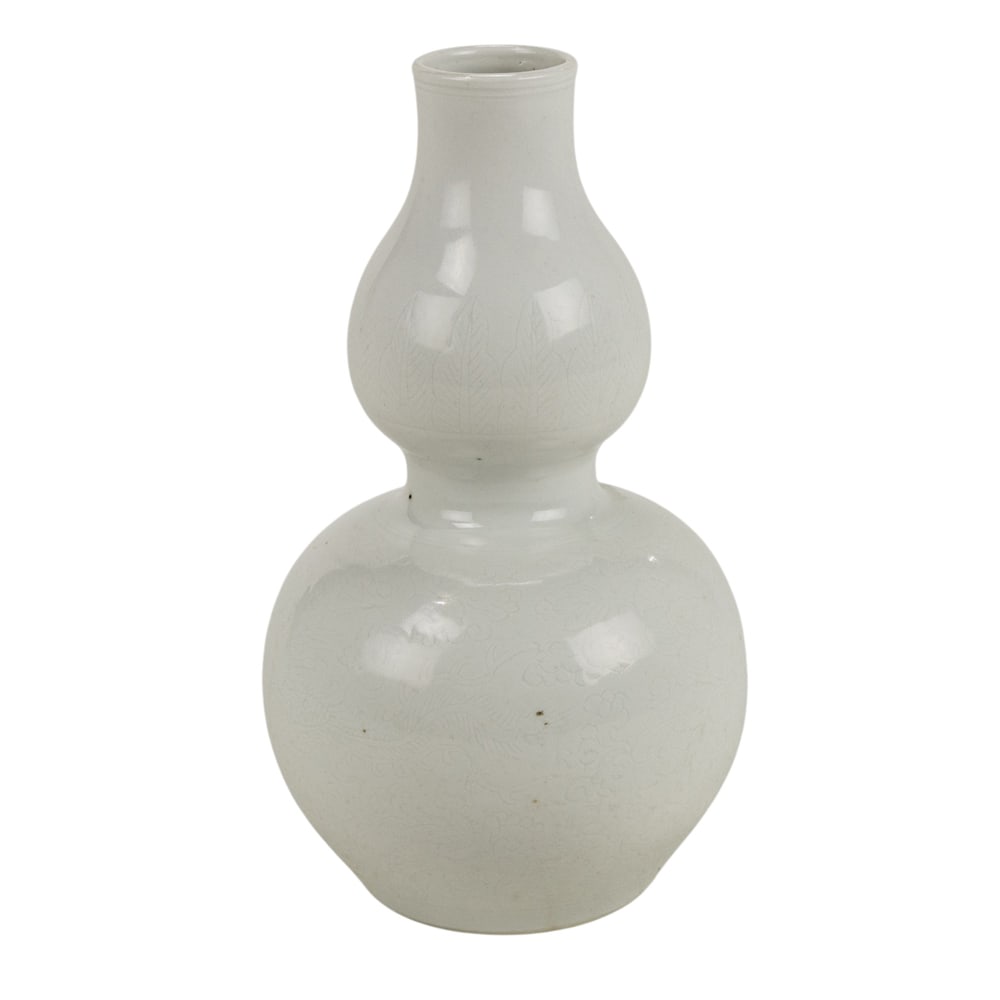 A Chinese white glazed and incised double-gourd form vase: A Chinese white glazed and incised double-gourd form vase. The bulbous bode decorated with a pair of phoenixes centering peony blossom, the based bearing an incised Chenghua six-character mark, 19th c
